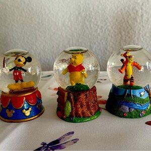 Three small Disney snow globes